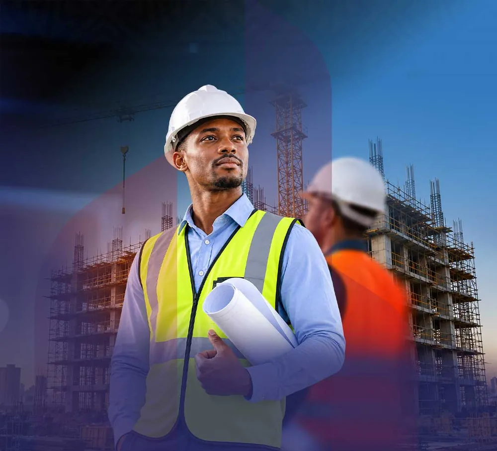 A construction professional in a hard hat holding building plans, with a building site behind