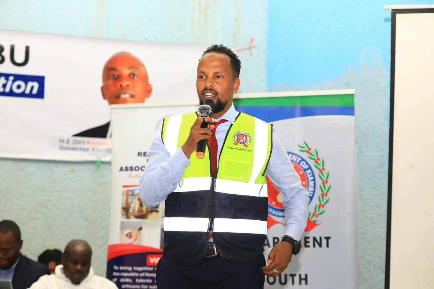 A Kiambu County official addressing participants wearing a county safety vest