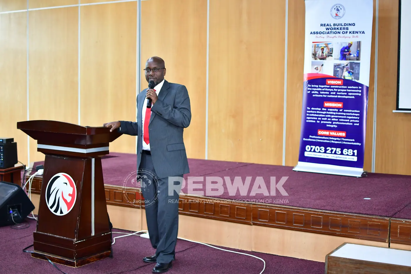 A KRA presenter addressing participants beside the REBWAK banner