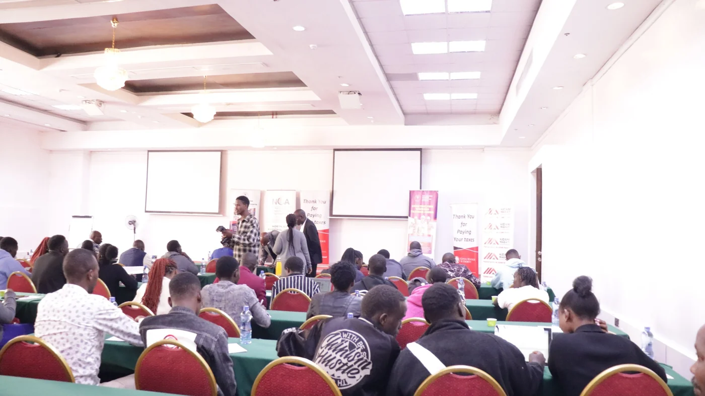 Participants facing the front of the hall with NCA and KRA banners at the NCA forum